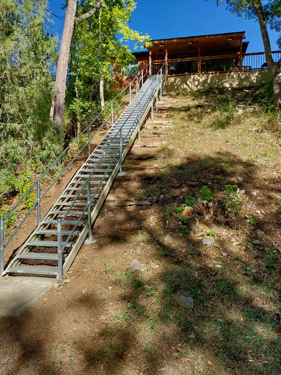 A long staircase climbing a steep lot to reach a house